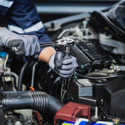 Professional mechanic working on the engine of the car in the ga Professional mechanic working on the engine of the car in the garage. Car repair service.